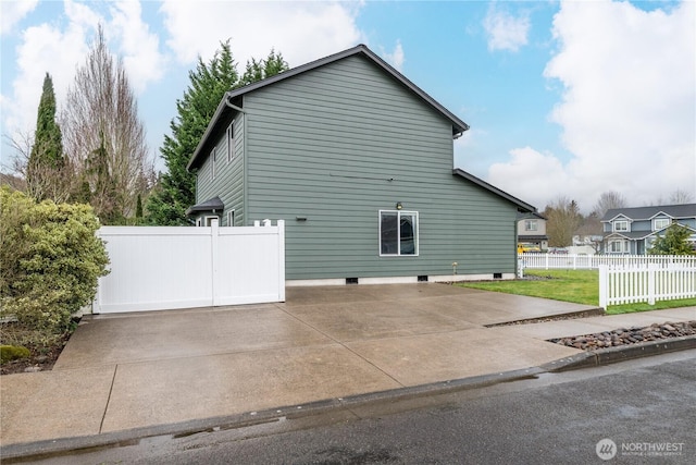 view of side of property featuring a lawn and fence