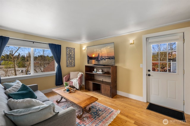 living room featuring a wealth of natural light, light wood finished floors, and baseboards