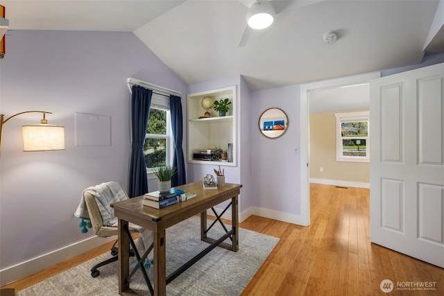 office space featuring light wood-style floors, vaulted ceiling, baseboards, and ceiling fan