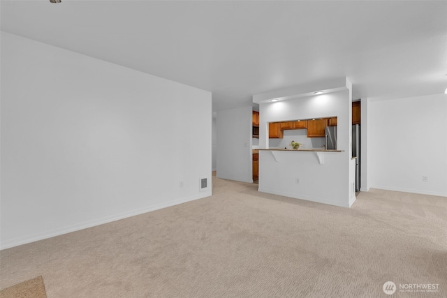 unfurnished living room with light carpet, baseboards, and visible vents