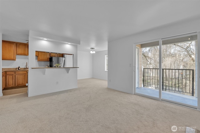 unfurnished living room with light carpet and baseboards