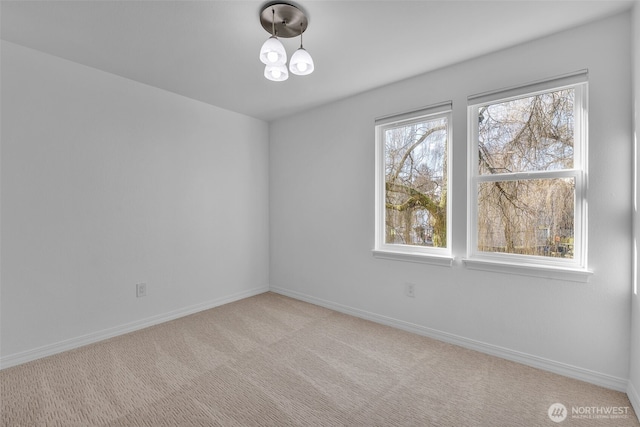 spare room featuring baseboards and carpet flooring