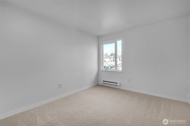 empty room with light carpet, baseboard heating, and baseboards