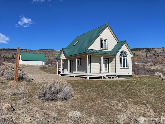 back of house with metal roof and a porch