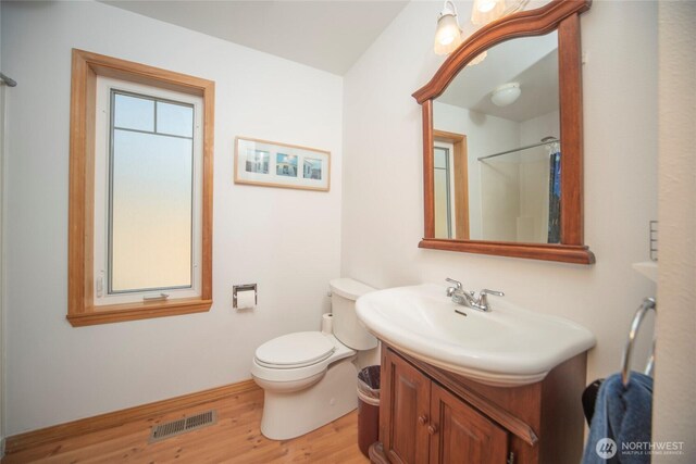 full bath featuring toilet, visible vents, wood finished floors, and vanity