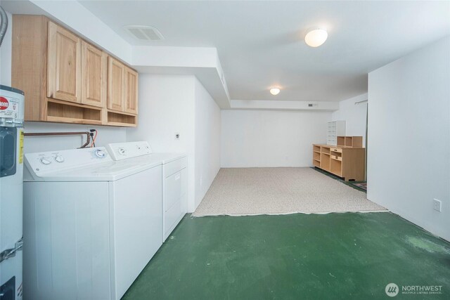 washroom with visible vents, cabinet space, and washer and clothes dryer