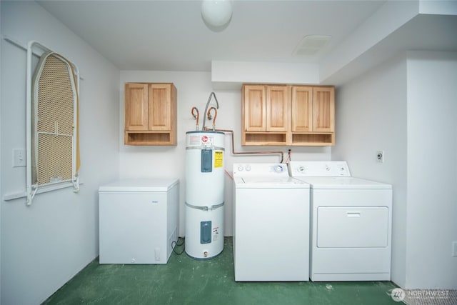 washroom featuring washer and dryer, water heater, and cabinet space