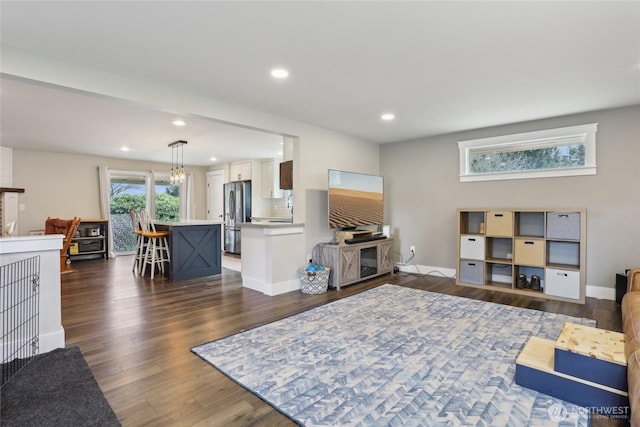 living room with dark wood-style floors, recessed lighting, a chandelier, and baseboards