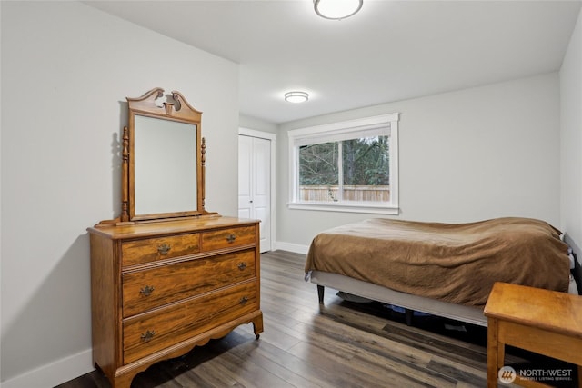 bedroom featuring a closet, baseboards, and dark wood-style flooring