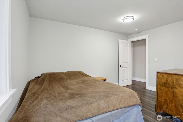 bedroom featuring dark wood-style flooring and baseboards