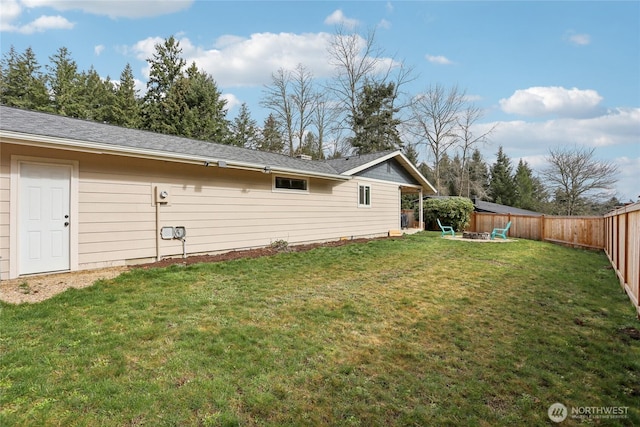 rear view of house featuring an outdoor fire pit, a lawn, and a fenced backyard