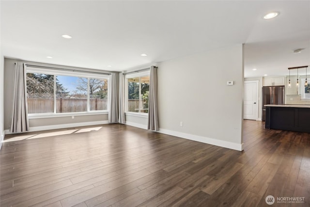 unfurnished living room featuring recessed lighting, baseboards, and dark wood finished floors