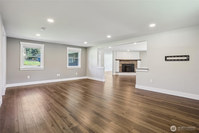 unfurnished living room featuring baseboards, recessed lighting, and dark wood-style flooring