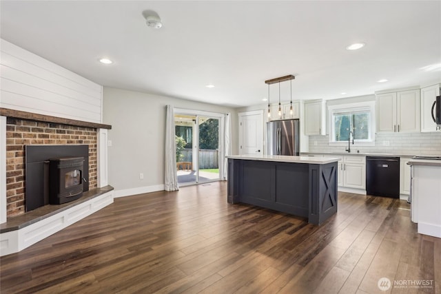 kitchen with a healthy amount of sunlight, white cabinets, freestanding refrigerator, and black dishwasher