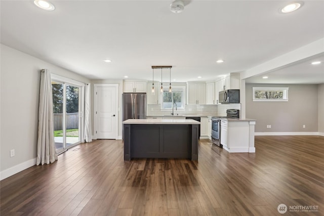 kitchen featuring a sink, stainless steel appliances, white cabinetry, and a healthy amount of sunlight