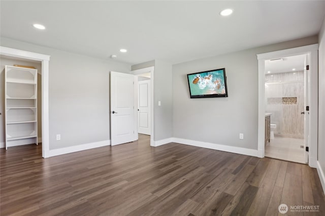 unfurnished bedroom with baseboards, dark wood-type flooring, recessed lighting, and a spacious closet