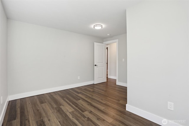 empty room with baseboards and dark wood-style floors