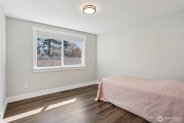 bedroom with baseboards, visible vents, and dark wood-type flooring