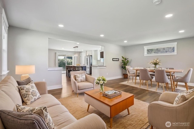 living area with recessed lighting, baseboards, and light wood-style flooring