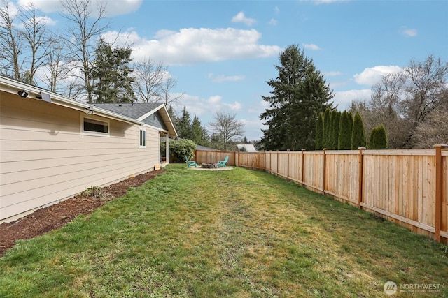 view of yard featuring a fenced backyard and a fire pit
