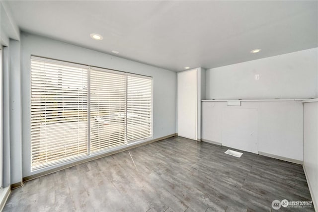 unfurnished bedroom featuring a closet, baseboards, wood finished floors, and recessed lighting