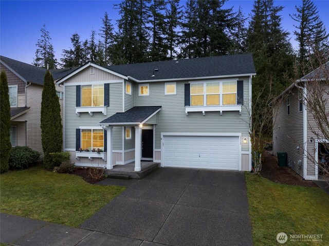 traditional home featuring concrete driveway, a front lawn, a garage, and a shingled roof