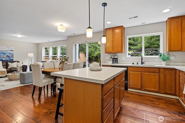 kitchen with visible vents, a sink, black dishwasher, open floor plan, and dark wood-style floors