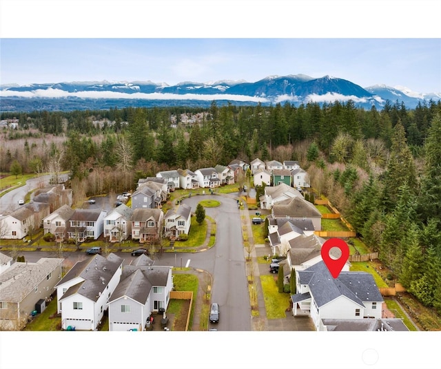 bird's eye view featuring a mountain view, a residential view, and a wooded view