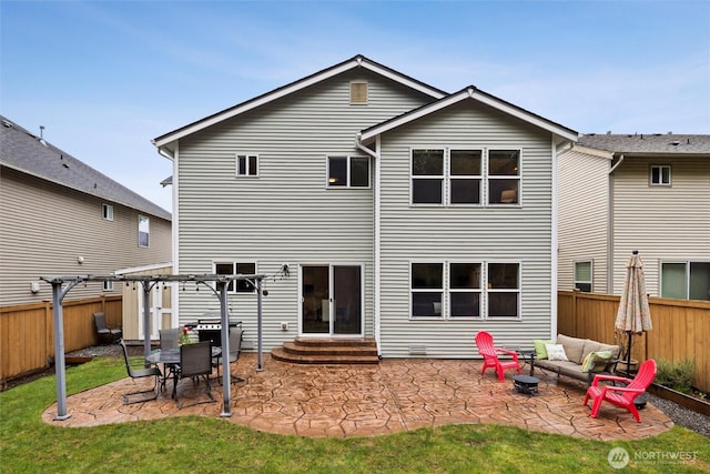 back of property with entry steps, a patio, a fenced backyard, and an outdoor fire pit