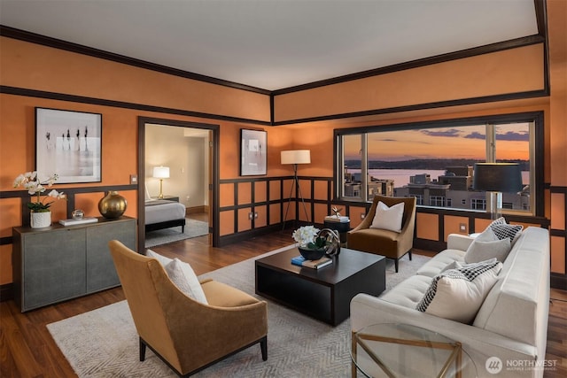 living area with ornamental molding, wood finished floors, and baseboards