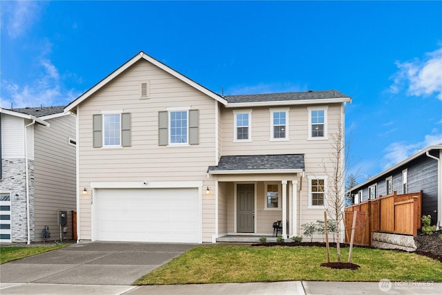 traditional home featuring a garage, concrete driveway, roof with shingles, fence, and a front lawn