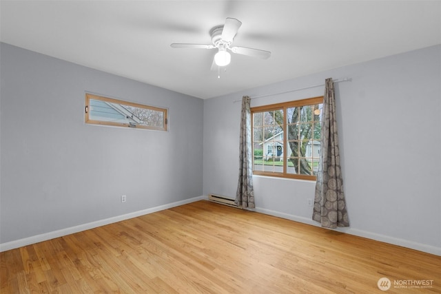 empty room with light wood-style flooring, baseboard heating, baseboards, and ceiling fan