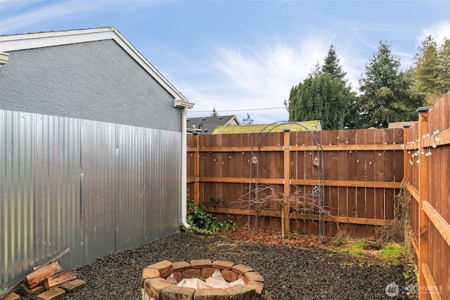 view of yard with an outdoor fire pit and fence