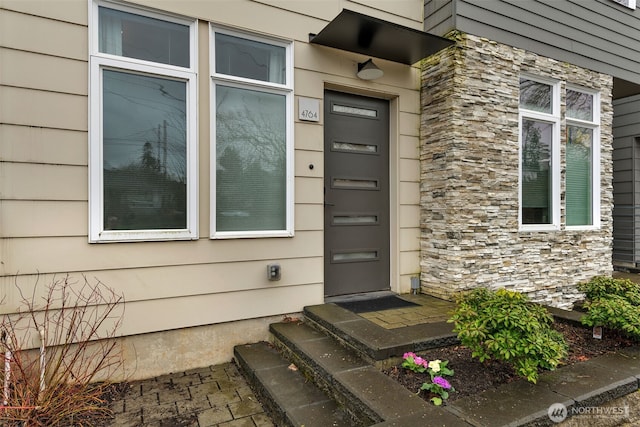 doorway to property featuring stone siding