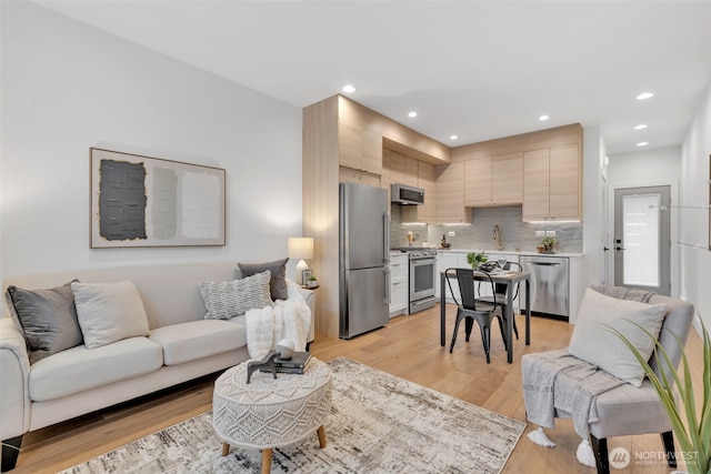 living area with light wood-style floors and recessed lighting