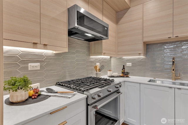 kitchen featuring appliances with stainless steel finishes, a sink, log walls, white cabinetry, and backsplash