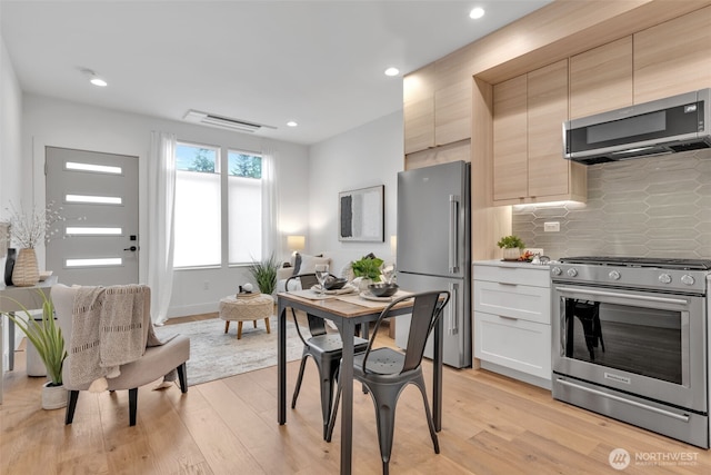 kitchen with stainless steel appliances, recessed lighting, tasteful backsplash, light countertops, and light wood-style floors