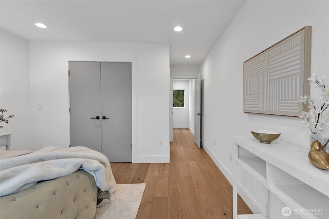 bedroom with light wood-style flooring, baseboards, a closet, and recessed lighting