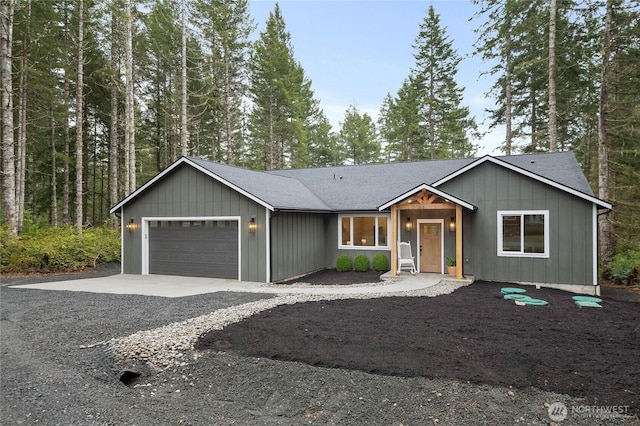 view of front of house with concrete driveway, a shingled roof, board and batten siding, and an attached garage