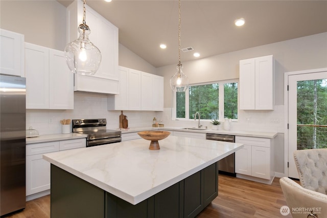 kitchen featuring visible vents, appliances with stainless steel finishes, white cabinets, and a sink