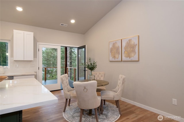 dining room featuring lofted ceiling, recessed lighting, visible vents, light wood-type flooring, and baseboards