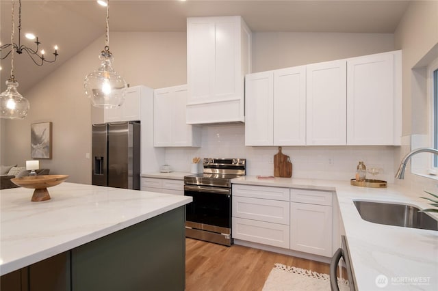 kitchen with lofted ceiling, light stone countertops, stainless steel appliances, and a sink