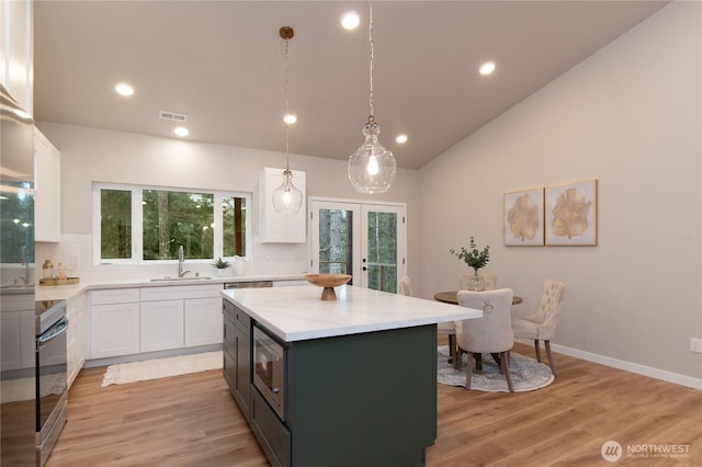 kitchen with stainless steel appliances, a sink, visible vents, and white cabinets