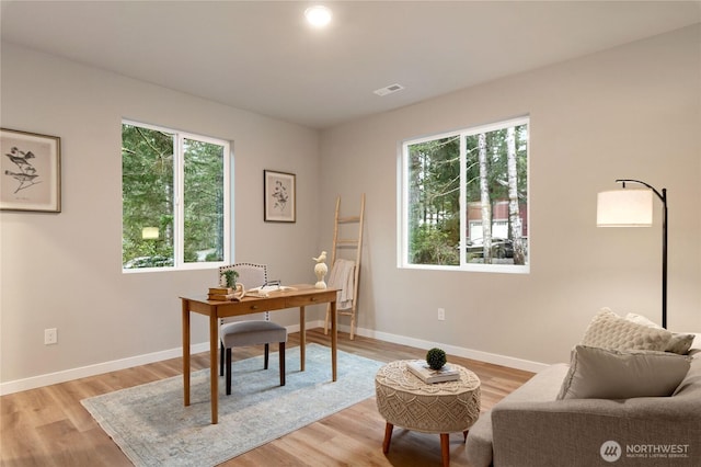 home office with baseboards, visible vents, and light wood finished floors