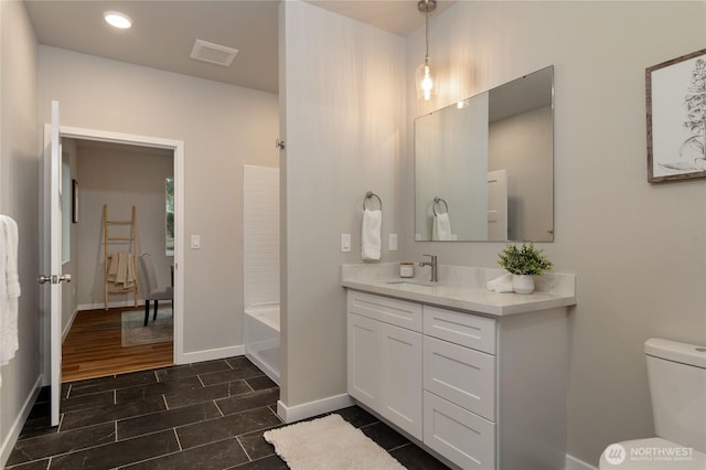 full bath with visible vents, baseboards, toilet, a bathing tub, and vanity