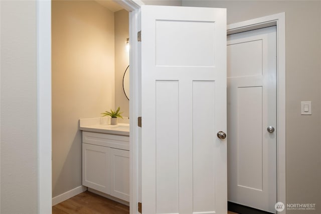 bathroom with vanity, baseboards, and wood finished floors