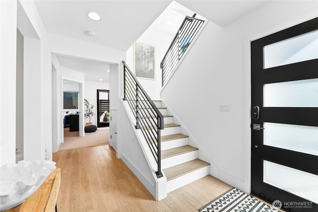 entrance foyer with stairs, light wood finished floors, baseboards, and recessed lighting