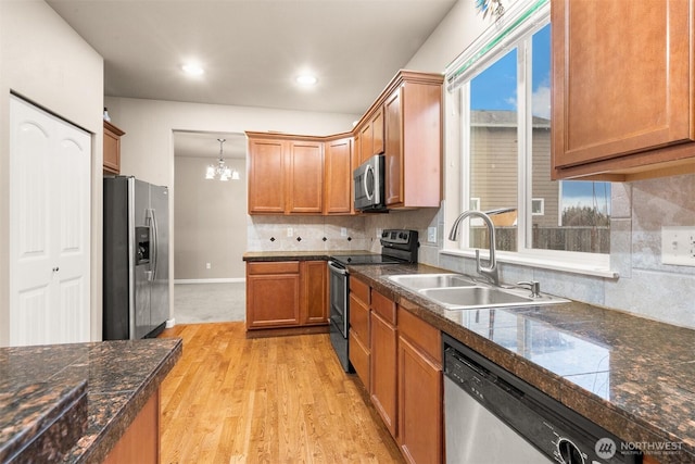 kitchen with tile counters, decorative backsplash, appliances with stainless steel finishes, a chandelier, and a sink