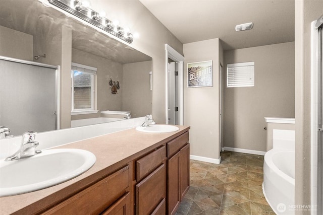 bathroom featuring double vanity, a sink, a bath, and baseboards