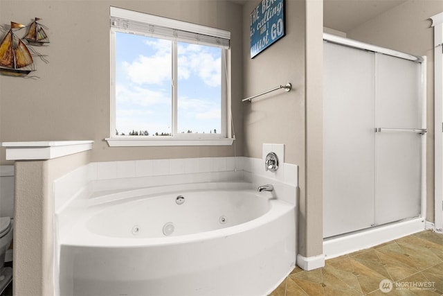 bathroom with a jetted tub, tile patterned flooring, a shower stall, and toilet